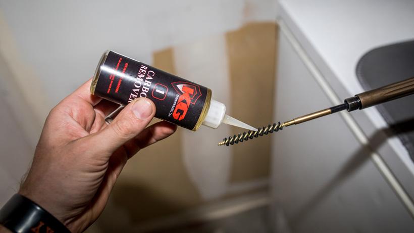 Placing carbon remover solvent on rifle bore brush